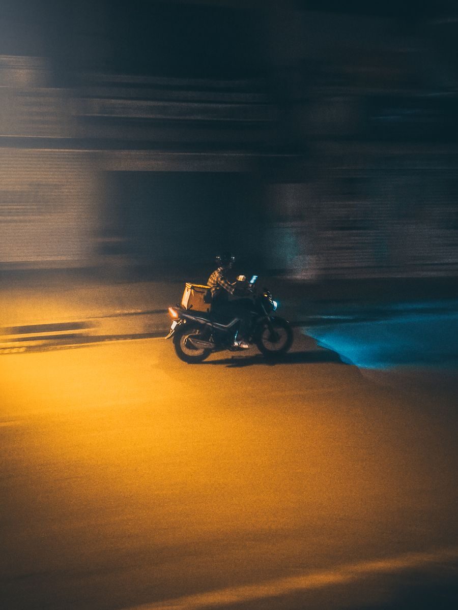Repartidor solo de noche en una calle poco iluminada
