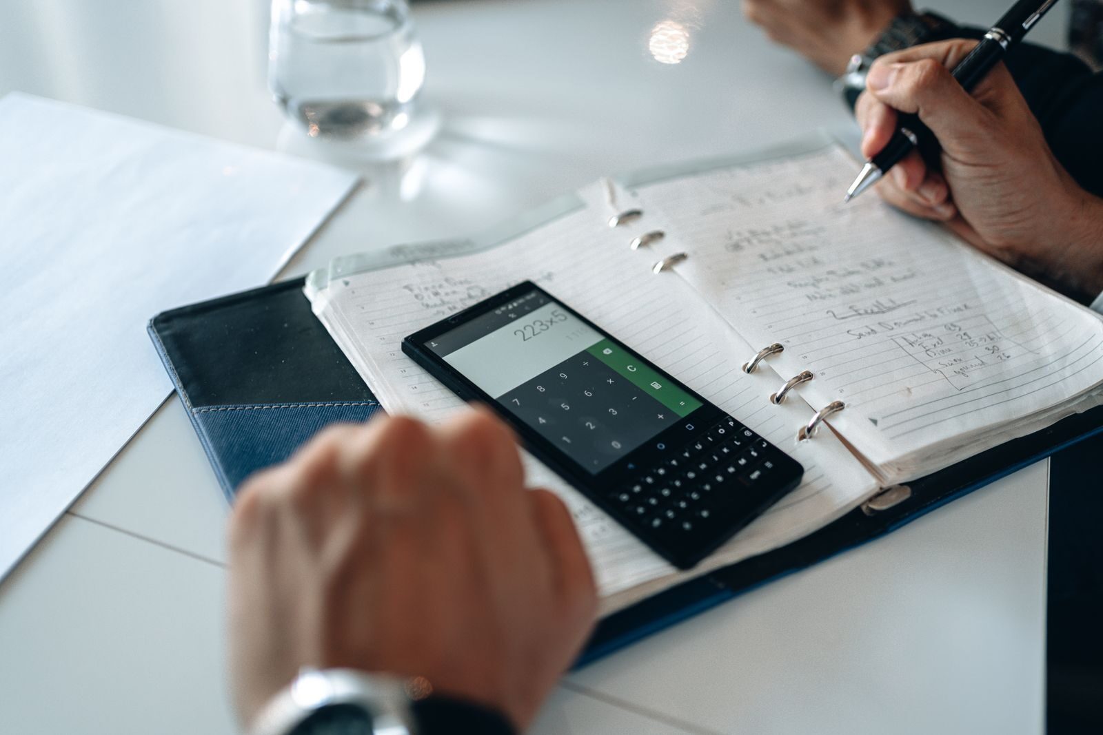 Libreta con cuentas a mano y calculadora para controlar los números del negocio